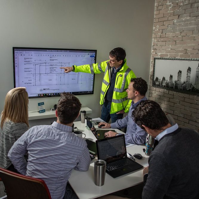 Project manager reviewing work with team